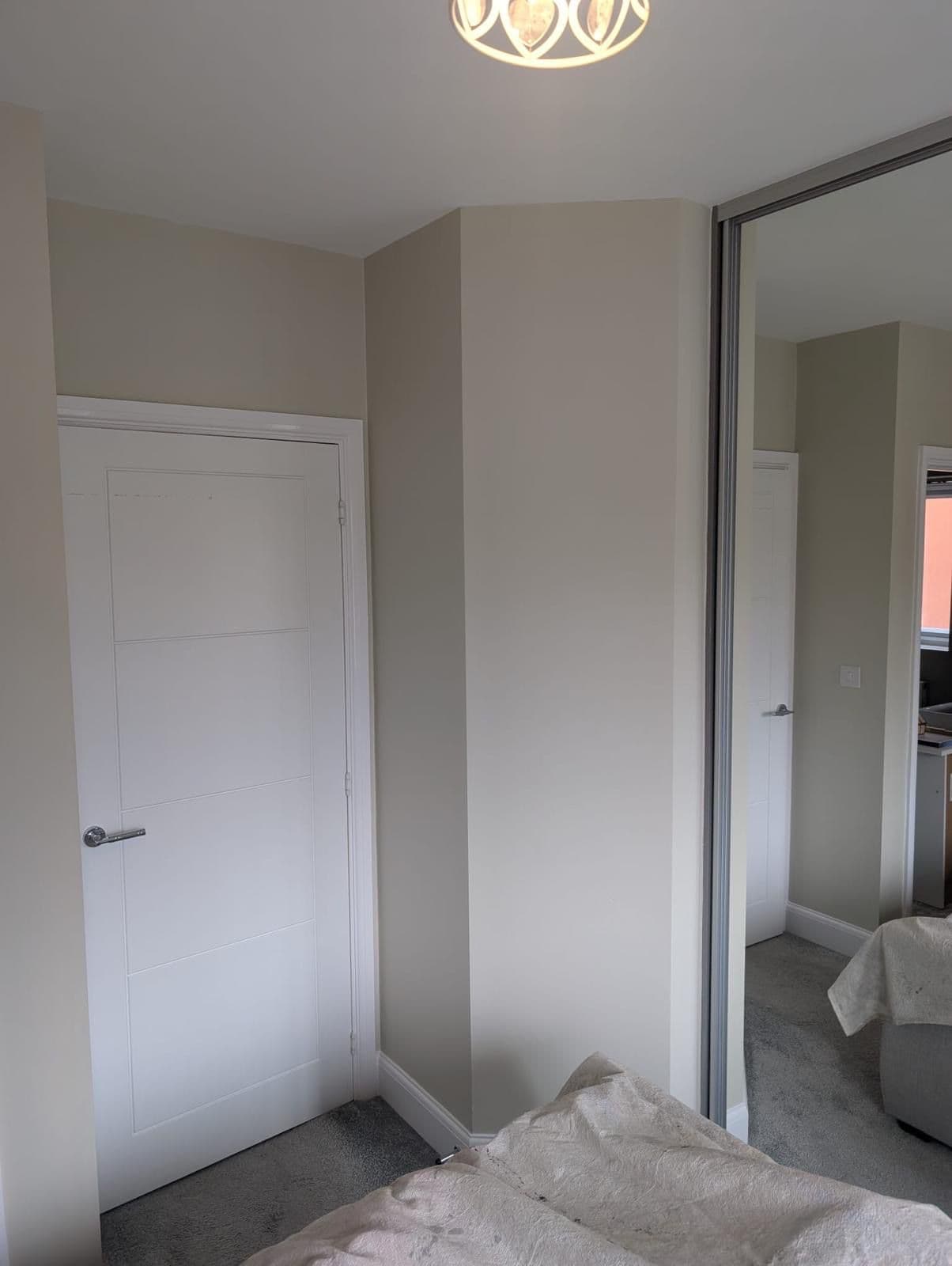 Bedroom freshly painted with neutral walls and white door